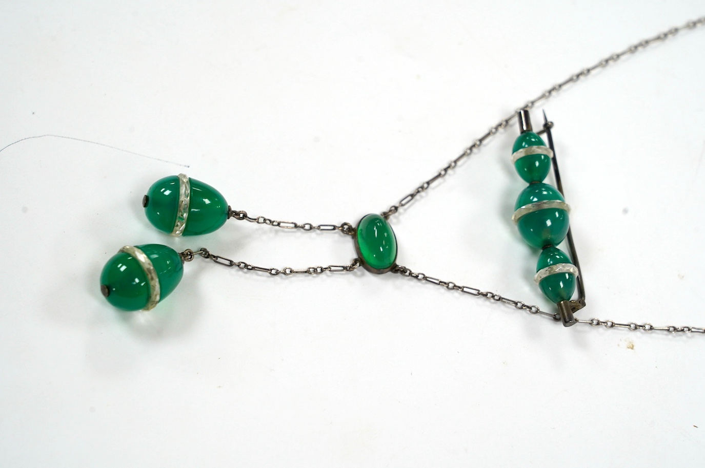 A white metal and green paste set double drop pendant necklace, 54cm and a similar brooch. Condition - fair to good